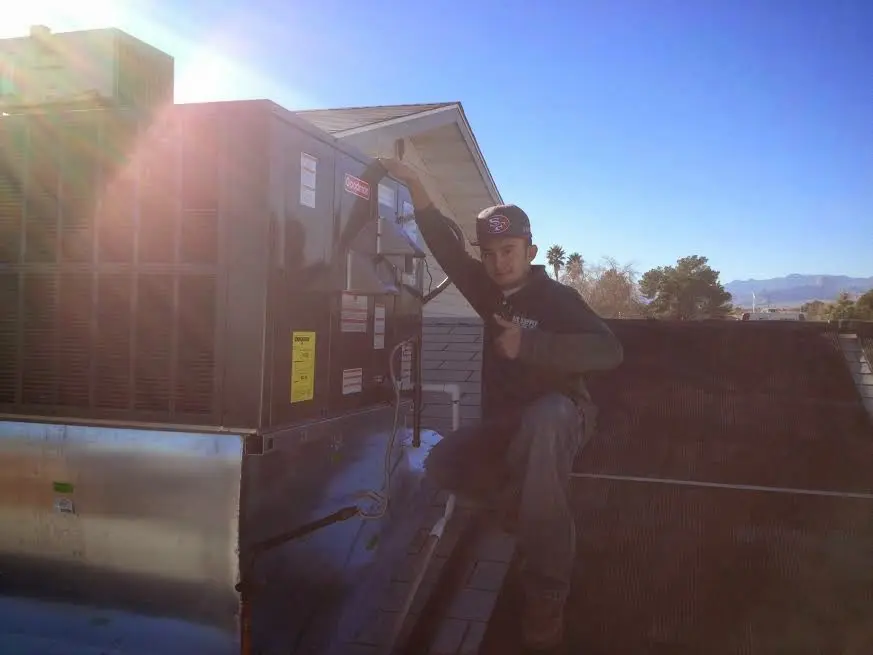 HVAC technician performing AC Tune-Up on a rooftop unit in West Hattiesburg
